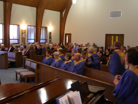 Choir members sit in the pews for sermon.