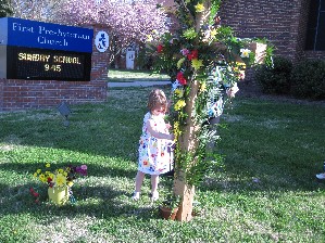 Children help placing flowers on the cross